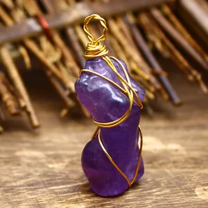 Detalle de primer plano de un colgante de torso femenino de amatista natural y oro