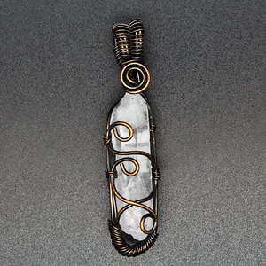 Close-up of handmade wire wrapped natural clear quartz crystal pendant on dark background