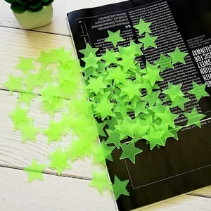 Macro view of light green glow in the dark 3D star wall stickers on a dark base.