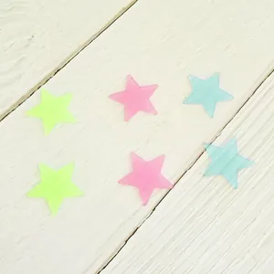 Macro view of 3D glow-in-the-dark star stickers in neon green, pink, and blue colors