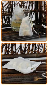 Gros plan sur sachets de thé jetables en non-tissé avec cordon sur fond en bambou.