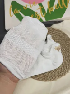 Nahaufnahme weißer atmungsaktiver Netzsocken mit filigraner Schleifenstickerei