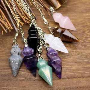 Various hexagonal natural stone crystal pendulums for dowsing on rustic wood background.