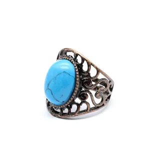 Detailed macro shot of a vintage bronze filigree ring featuring a blue oval stone