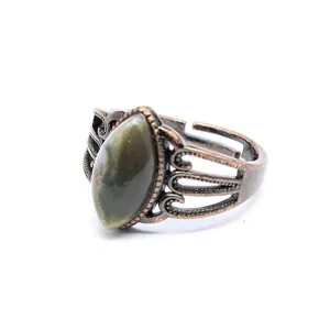 Dettaglio ravvicinato di un anello vintage in rame antico con pietra naturale verde