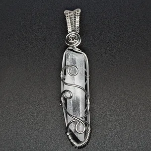 Close-up of handmade silver wire-wrapped clear quartz crystal hexagonal point pendant