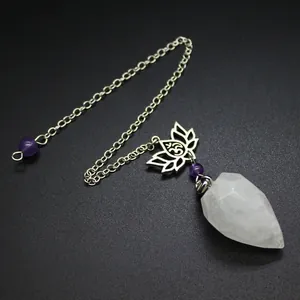Close-up of a faceted clear crystal pendulum with a lotus metal charm and chain.