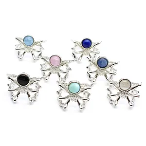 Detailed view of assorted spider-shaped open rings with various colorful gemstones.