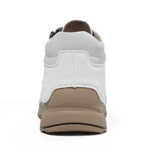 Detailed back view of white casual shoe featuring a tan soft sole and handmade stitching.
