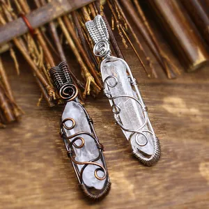 Macro view of wire-wrapped natural white crystal hexagonal point pendants on rustic wood.