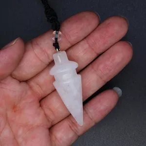 Close-up detail of a rose quartz crystal pendulum pendant held in hand for scale