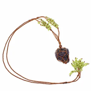 Handcrafted Bohemian necklace with raw purple stone in woven mesh and peridot chips
