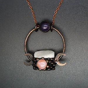 Close-up of medieval vintage pendant necklace with crystal and amethyst-like stones