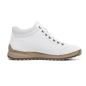 Side profile view of premium white hand-stitched casual shoes with a soft beige sole.