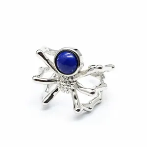 Detailed macro view of silver spider open ring with round blue natural stone inlay