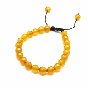 Detailed view of 8mm yellow natural stone beads on a hand-woven adjustable bracelet.