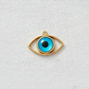 Dettaglio del ciondolo malocchio in acciaio inossidabile dorato con occhio blu e zircone.