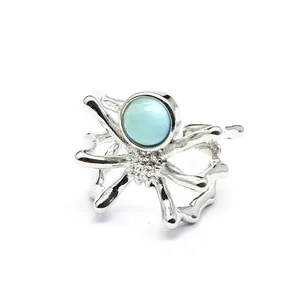 Close-up view of a unique silver spider open ring featuring a round light blue natural stone.