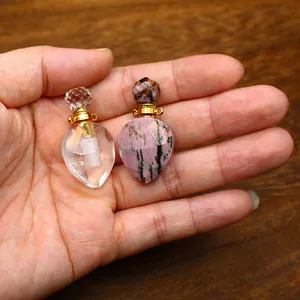 Detail view of mini faceted crystal and rhodonite gemstone perfume bottle pendants.
