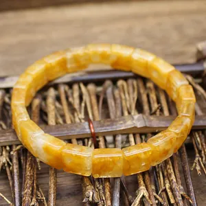 Macro detail of natural square faceted citrine beads on a rustic wooden bracelet.