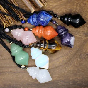 Detailed view of various gemstone conical pendants with braided ropes on a wooden surface.