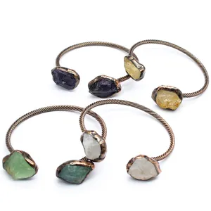 Multiple vintage copper cuffs featuring diverse natural raw crystal stones in various colors.