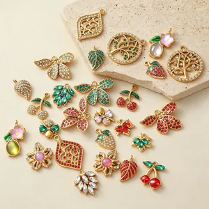 Detail view of colorful gold-plated charms with zirconia and strawberry motifs