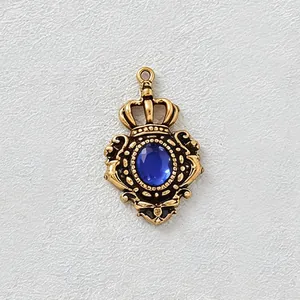 Vista dettagliata del ciondolo a corona dorata vintage con pietra blu per gioielli DIY