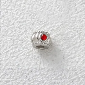 Close-up detail of silver stainless steel bead with red cubic zirconia for DIY jewelry