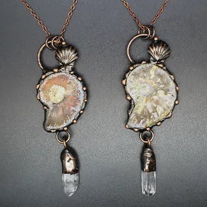 Detailed view of vintage medieval style ammonite fossil pendants with white crystal points
