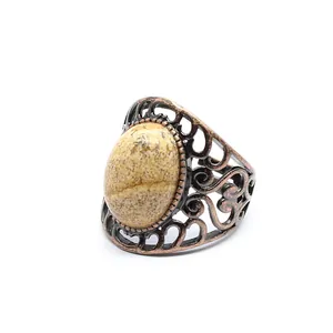 Detailed view of a vintage bronze hollow ring with a natural oval jasper stone inlay.