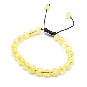 Detailed view of 8mm natural yellow stone beads on hand-woven adjustable bracelet