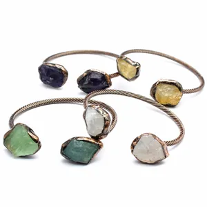 Close-up of vintage style open bangles featuring natural irregular raw crystal stones