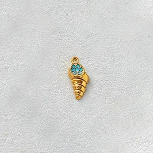 Detailed macro shot of a gold-plated stainless steel conch pendant with blue zircons