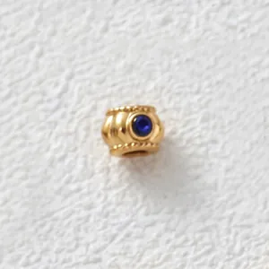 Close-up of gold-plated stainless steel bead with inlaid blue zircon for DIY jewelry