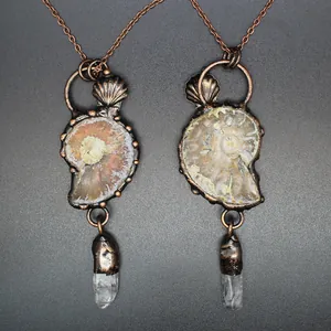 Macro view of two vintage ammonite fossil necklaces with natural white crystal points
