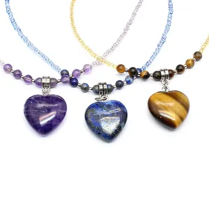 Detailed view of natural stone heart necklaces in amethyst, lapis, and tiger eye styles