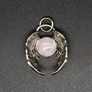 Macro view showing the intricate detail of silver angel wings cradling a rose quartz bead.