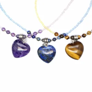 Detailed view of natural amethyst, lapis lazuli, and tiger eye heart necklaces on beaded chains
