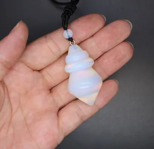 Detailed macro view of opalite cone pendant with black adjustable cord held in hand