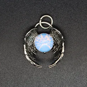 Detailed close-up of a vintage silver angel wings pendant featuring a glowing blue opalite bead