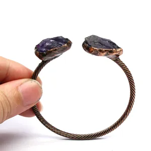 Detail view showing the vintage copper twisted bangle with raw purple amethyst stones.