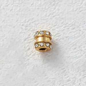Detailed macro view of a gold-plated stainless steel bead featuring sparkling CZ inlays