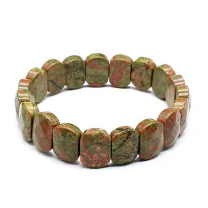 Detailed macro view of a natural Unakite stone stretch bracelet with flat oval beads.
