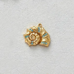 Close-up detail of a gold-plated conch shell pendant with light blue zircon stone inlays.