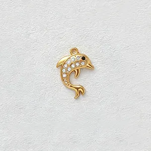 Macro view of gold-plated stainless steel dolphin charm with white zircon inlay.