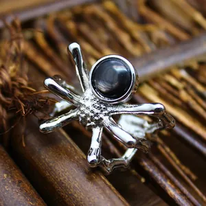 Macro view of a Gothic silver spider ring featuring a black natural stone centerpiece detail