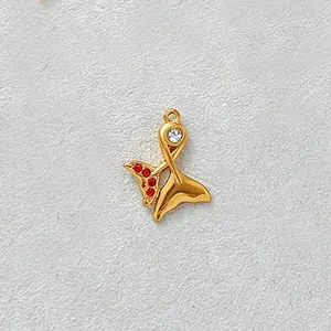 Detail view of gold-plated mermaid tail pendant with red and clear zircon stones