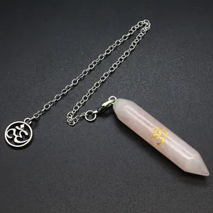 Dettaglio di pendolo esagonale in quarzo rosa con simbolo Om dorato su catena d'argento.