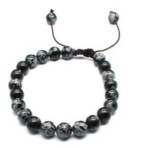 Macro view of 8mm snowflake obsidian natural stone beads on a handmade braided bracelet.
